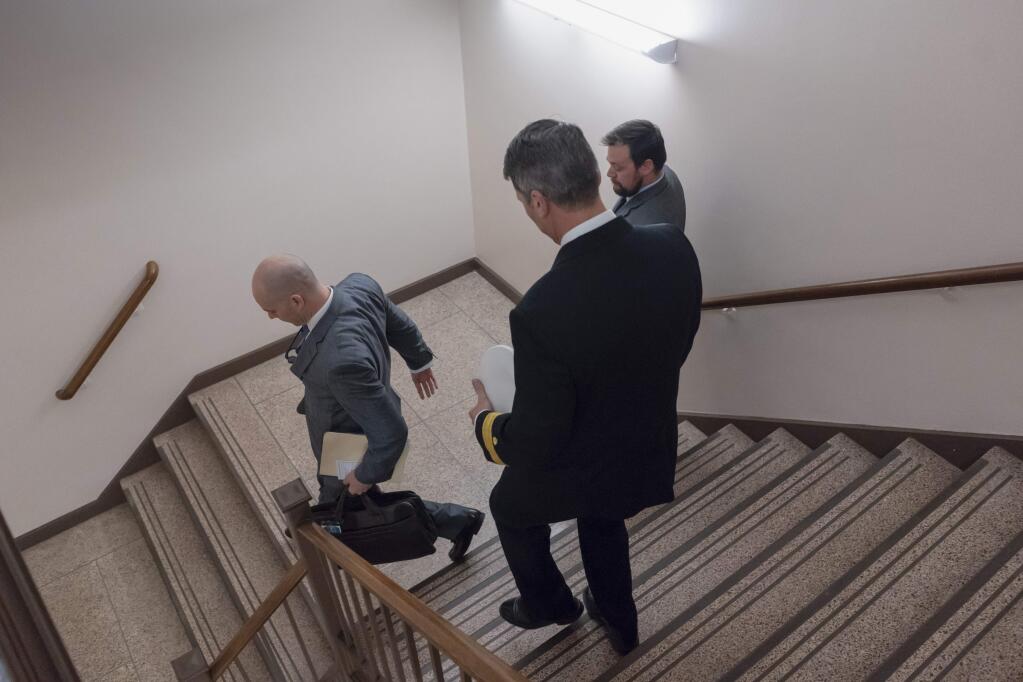 Rear Adm. Ronny Jackson, center, President Donald Trump's choice to be secretary of the Department of Veterans Affairs, walks down a stairwell to avoid reporters and cameras as he leaves a Senate office building after meeting individually with some members of the committee that would vet him for the post, on Capitol Hill in Washington, Tuesday, April 24, 2018. (AP Photo/J. Scott Applewhite)
