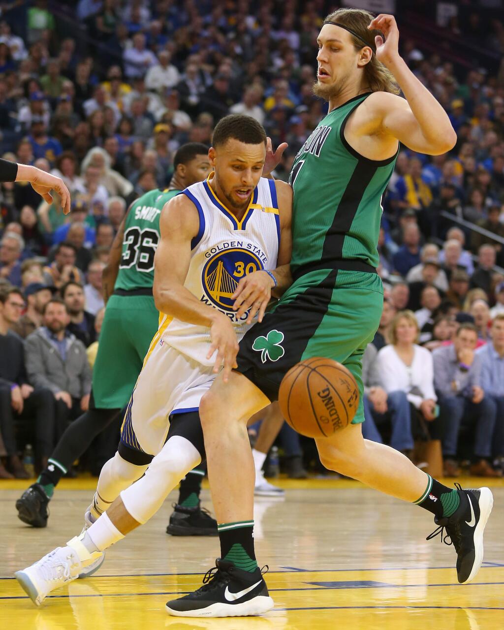 Golden State Warriors guard Stephen Curry drives around Boston Celtics forward Kelly Olynyk in Oakland on Wednesday, March 8. (Christopher Chung/ The Press Democrat)