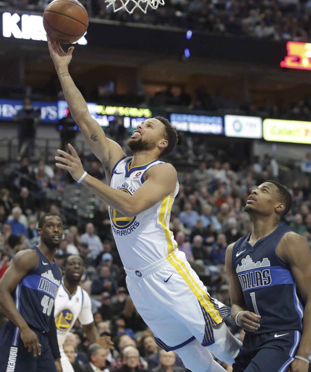 Golden State Warriors guard Stephen Curry (30) drives past Dallas Mavericks guard Dennis Smith Jr. (1) during the first half of an NBA basketball game in Dallas, Wednesday, Jan. 3, 2018. (AP Photo/LM Otero)