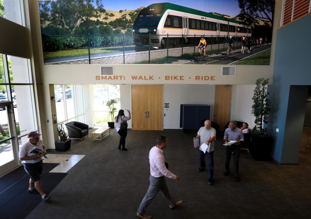 People walk through the lobby of SMART's headquarters in Petaluma to attend a board meeting of the North Bay's commuter rail agency on Wednesday, July 17, 2019. More than two hours of the meeting included discussion of the five recent deaths on the SMART tracks in Sonoma County. (Kent Porter / The Press Democrat) 2019