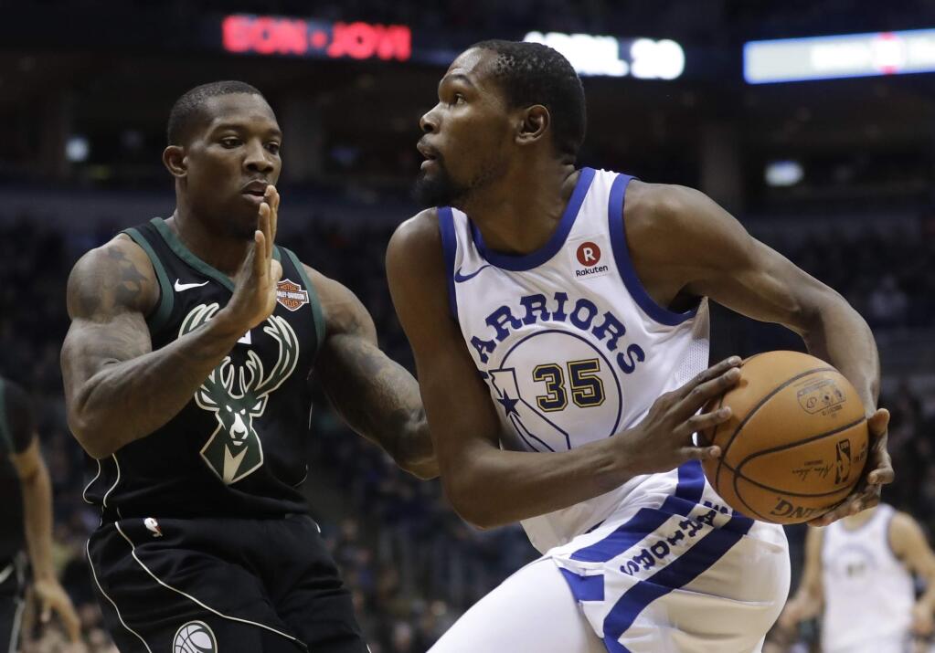 The Golden State Warriors' Kevin Durant drives past the Milwaukee Bucks' Eric Bledsoe during the first half Friday, Jan. 12, 2018, in Milwaukee. (AP Photo/Morry Gash)