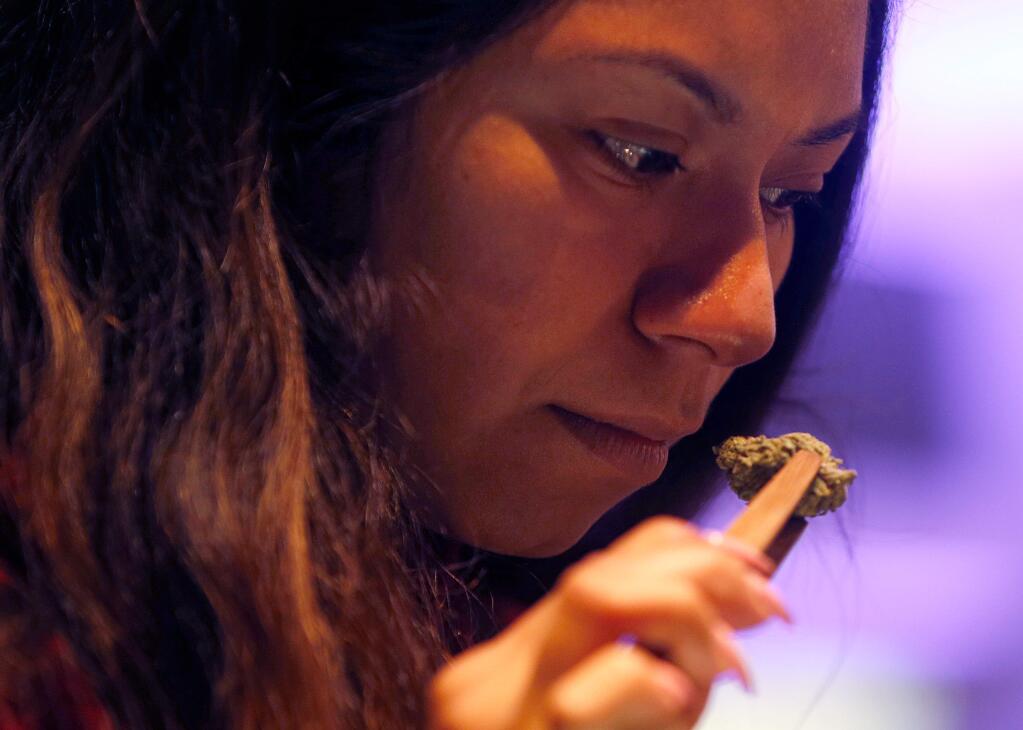 Reyna Herrera of Cloverdale takes in the scent of some marijuana buds at Emerald Pharms cannabis dispensary in Hopland, California, on Thursday, March 1, 2018. (Alvin Jornada / The Press Democrat)