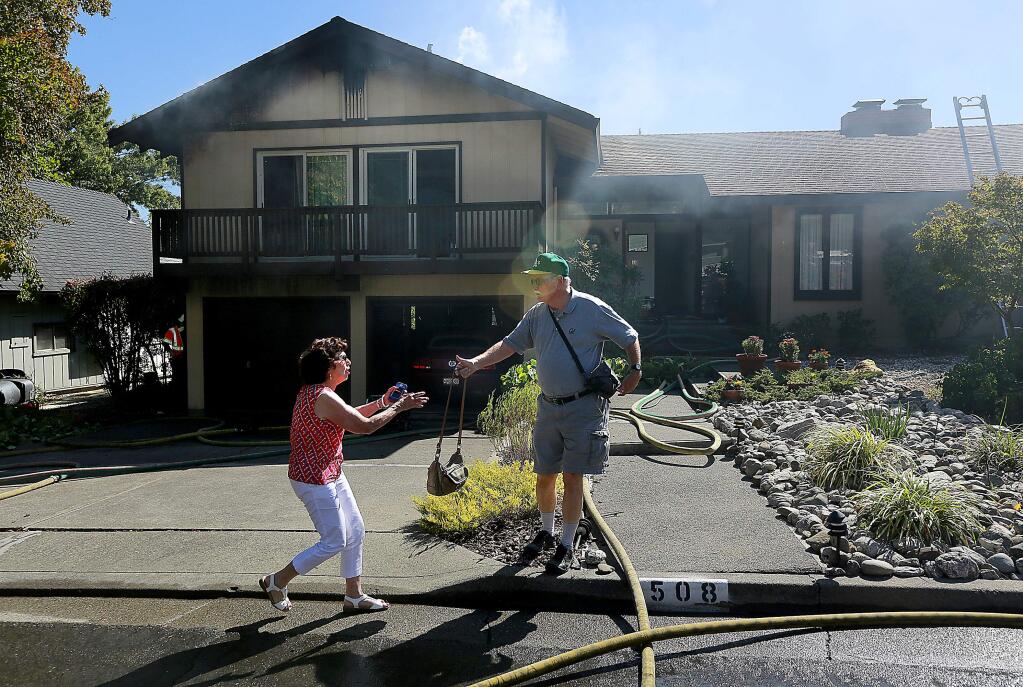 Homeowners hand off items on Buena Vista Road in Santa Rosa on Saturday, Aug. 30, 2014. (The Press Democrat)