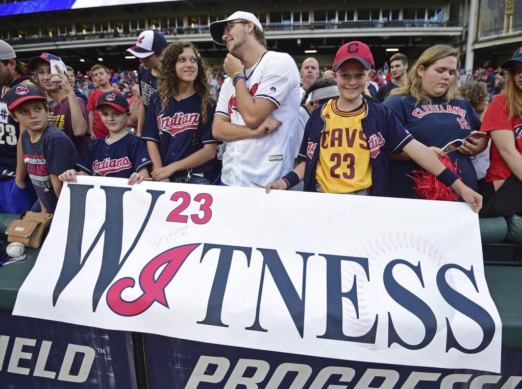 Cleveland Indians fans hold a sign before a baseball game between the Indians and the Kansas City Royals, Friday, Sept. 15, 2017, in Cleveland. (AP Photo/David Dermer)
