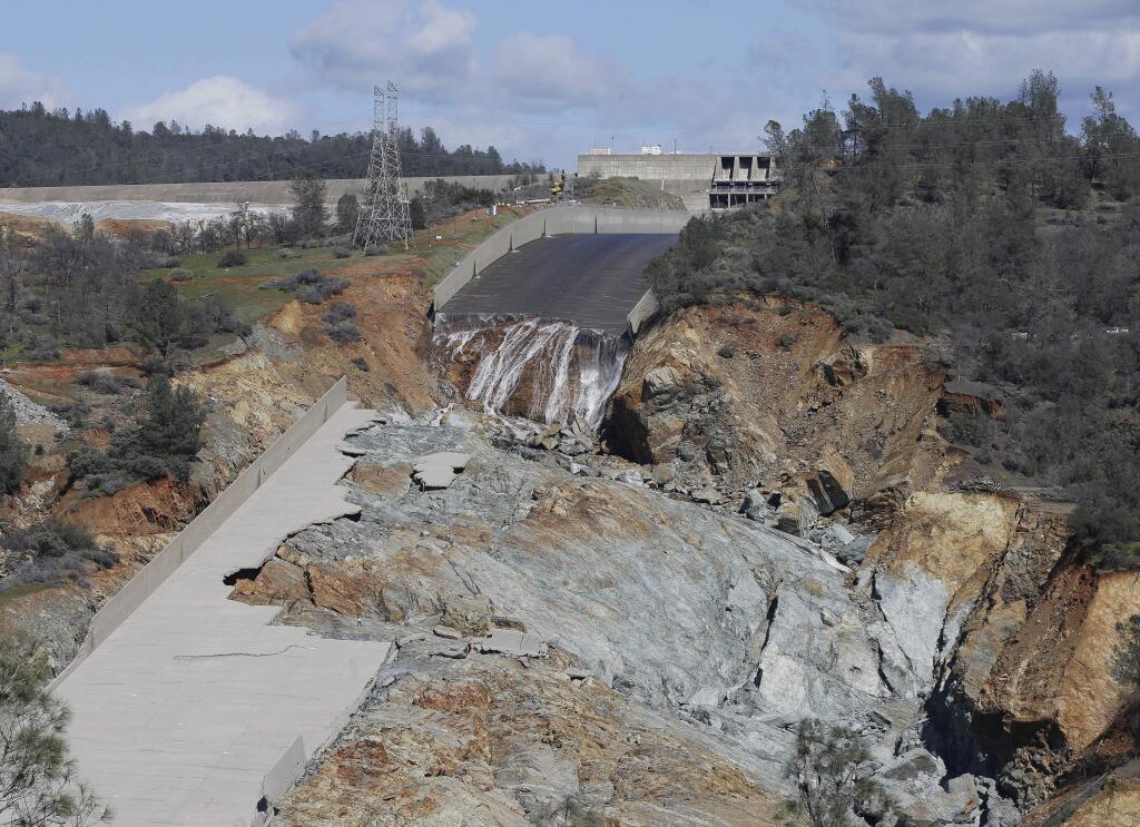 FILE - In this Feb. 28, 2017, file photo, a small flow of water goes down Oroville Dam's crippled spillway in Oroville, Calif. A towering spillway at the nation's tallest dam was crumbling and tens of thousands of people were fleeing for their lives, but as darkness fell state managers suddenly discovered the unfolding crisis in Northern California was about to get even worse: They couldn't see. For years federal regulators had urged keepers at the state-run Oroville Dam to install more cameras and other monitors to warn and guide them in just such an emergency. (AP Photo/Rich Pedroncelli, File)