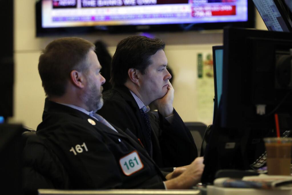 A pair of traders work on the floor of the New York Stock Exchange, Monday, Feb. 24, 2020. Markets are down across Europe and Asia, while futures for U.S. benchmarks have also dropped sharply. (AP Photo/Richard Drew)