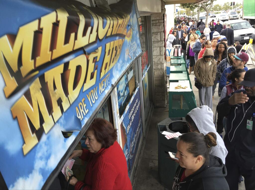 FILE - In this Jan. 13, 2016, file photo, customers wait in line outside the Blue Bird Liquor store to buy Powerball lottery tickets in Hawthorne, Calif. (AP Photo/Damian Dovarganes, File)