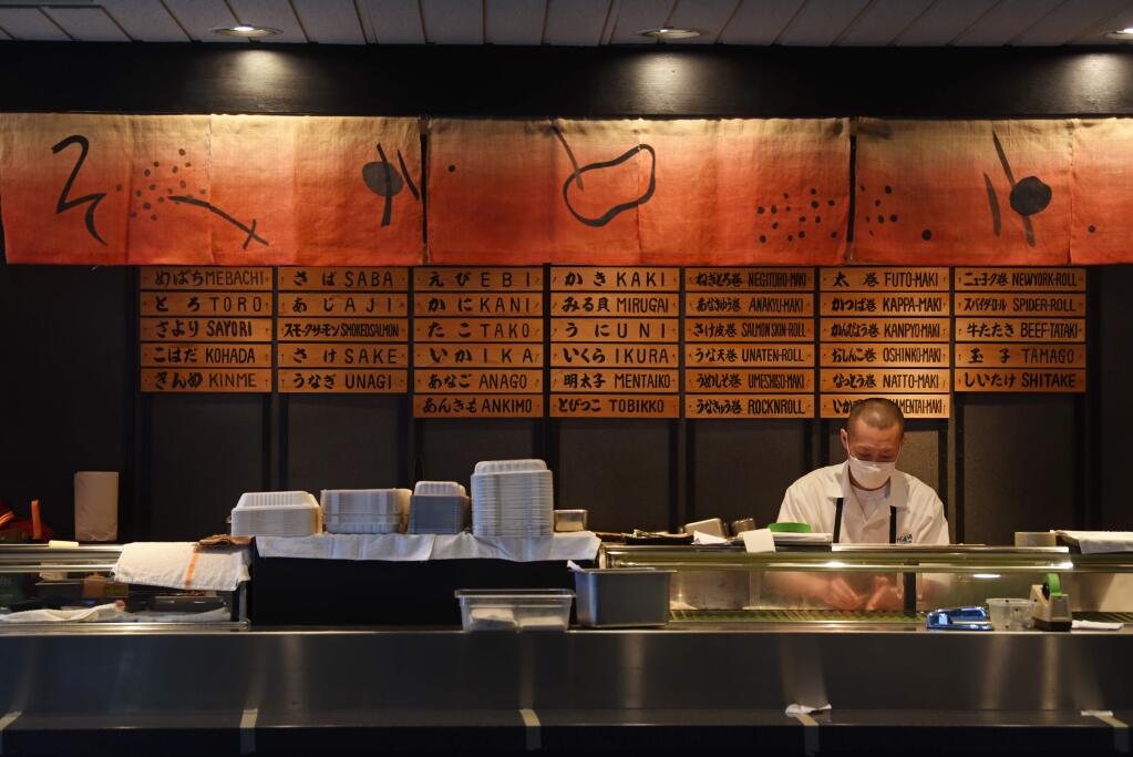 Taka Uchida makes sushi at an empty bar for take-out orders only at Hana Japanese Restaurant in Rohnert Park on Tuesday, April 28, 2020. (Erik Castro/For The Press Democrat)