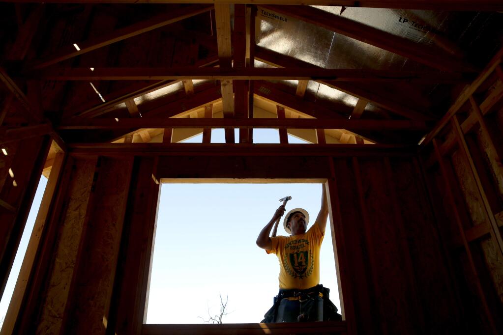 Juan Cabrera frames a window of a home being built by Silvermark Construction Services on Willow Green Place in the unincorporated area of Sonoma County. Photo taken near Santa Rosa on Thursday, June 21, 2018. (Beth Schlanker/ The Press Democrat)