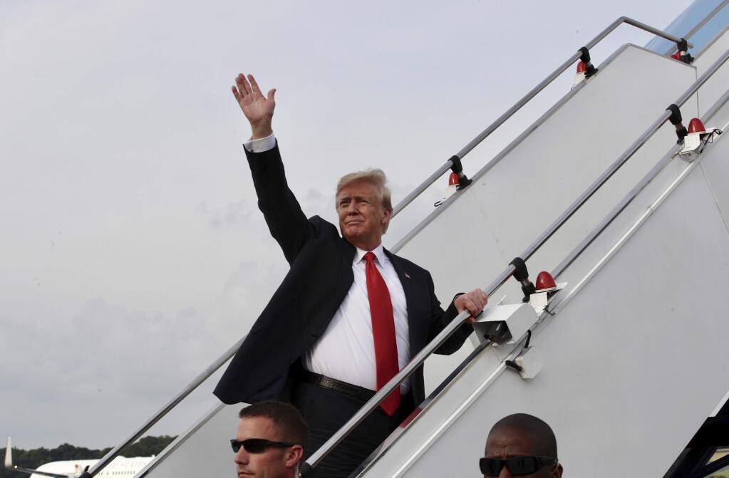 In this photo released by the Ministry of Communications and Information, Singapore, U.S. President Donald Trump waves as he boards Air Force One following a summit with North Korean leader Kim Jong Un Tuesday, June 12, 2018 in Singapore. (Ministry of Communications and Information, Singapore via AP)