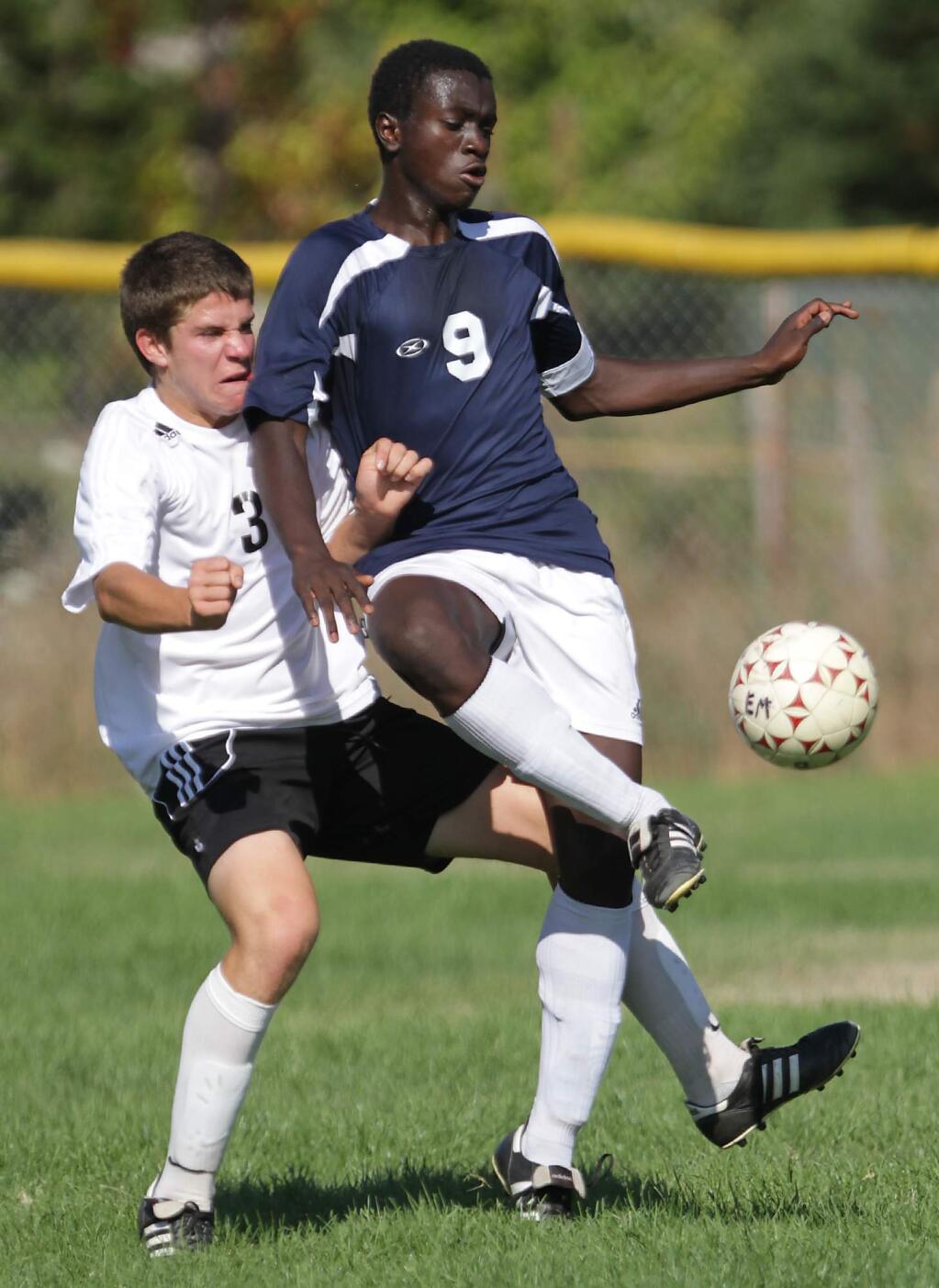 Rancho Cotate's Roy Boateng passes the ball as El Molino's Mitch Parsons pressures him during a 2011 game held at El Molino High School. (Press Democrat file)
