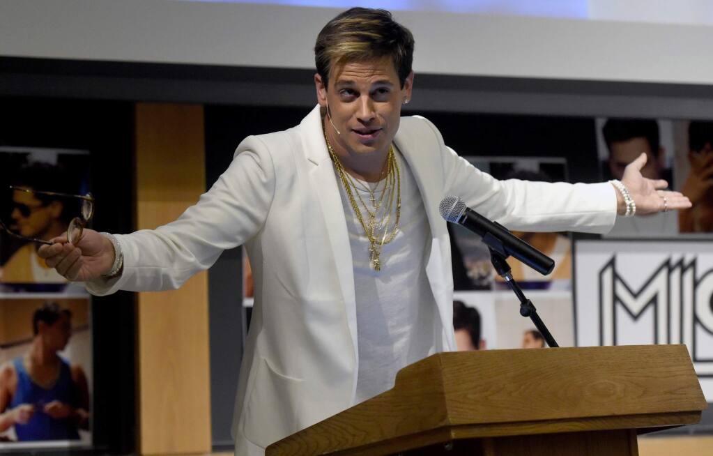 FILE - In this Jan. 25, 2017 file photo, Milo Yiannopoulos speaks on campus in the Mathematics building at the University of Colorado in Boulder, Colo. Sales are soaring for, 'Dangerous,' the upcoming book by the right-wing commentator. The book, originally scheduled to come out March 14, has now been rescheduled for June so that it can include the violent protests that canceled his talk at University of California, Berkeley. (Jeremy Papasso/Daily Camera via AP, File)