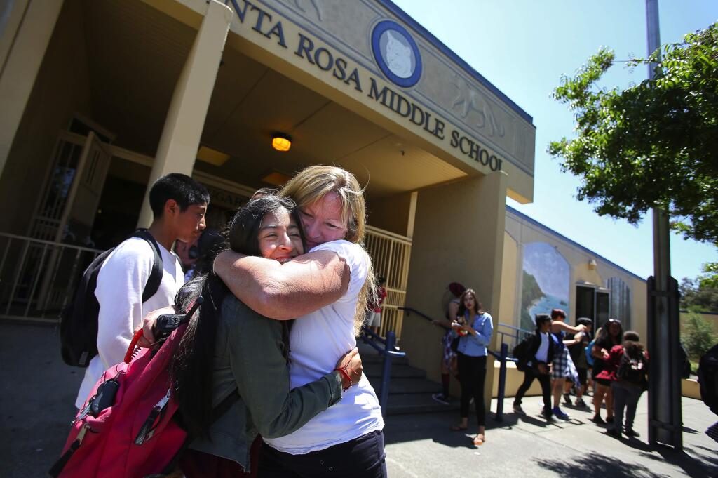 Retiring Santa Rosa Middle School principal Kathy Coker receives a hug from eighth-grader Jackie Sosa on the last day of school on Friday, June 5, 2015. (CHRISTOPHER CHUNG/ PD)