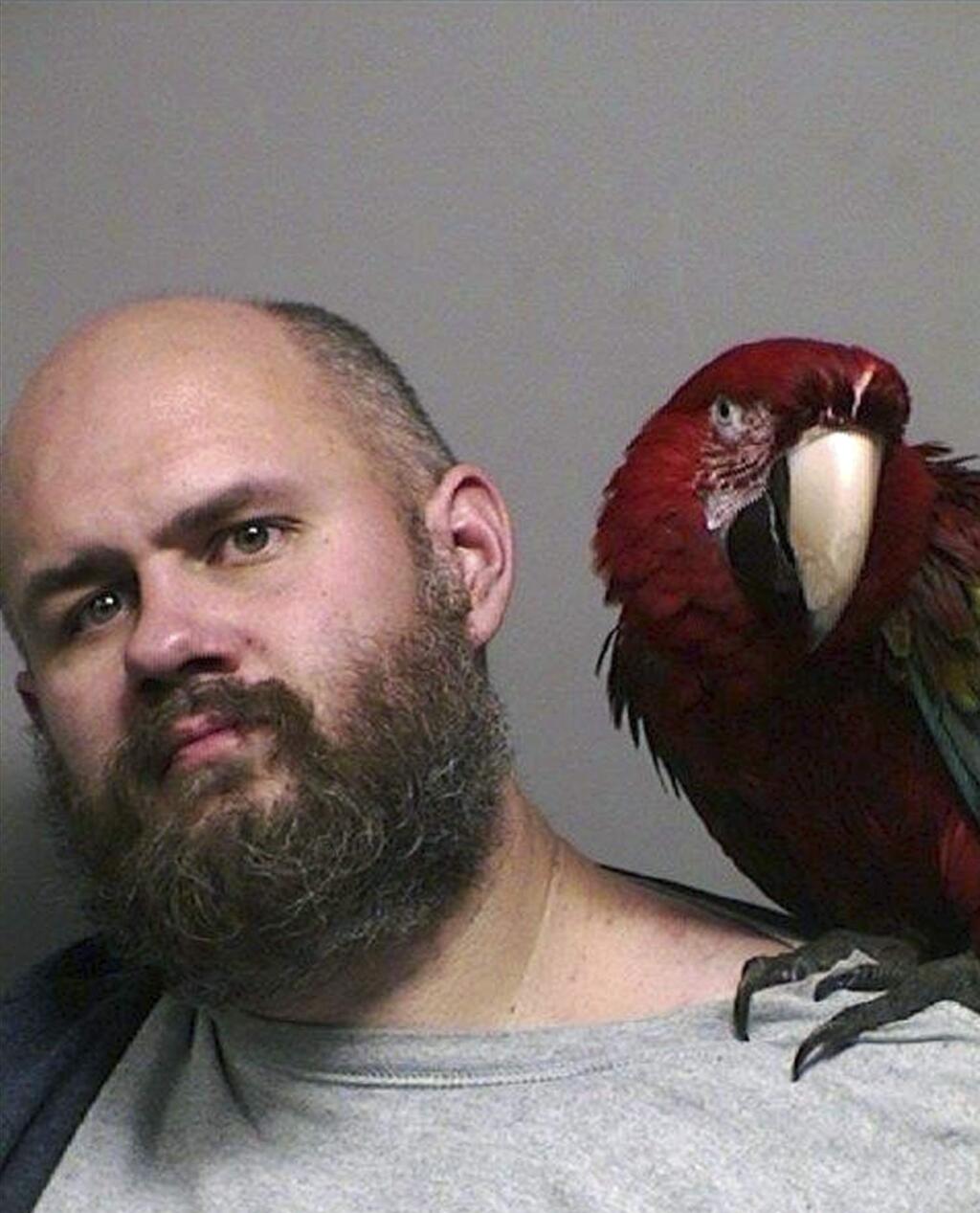 This booking photo provided by the Washington County Sheriff's office taken in Hillsboro, Ore., Thursday, Dec. 1, 2016, shows Craig Buckner with his macaw, named 'Bird.' The 4-year-old macaw became an instant celebrity after appearing in the booking mug shot with his unfortunate owner. (Multnomah County Sheriff's Office via AP)