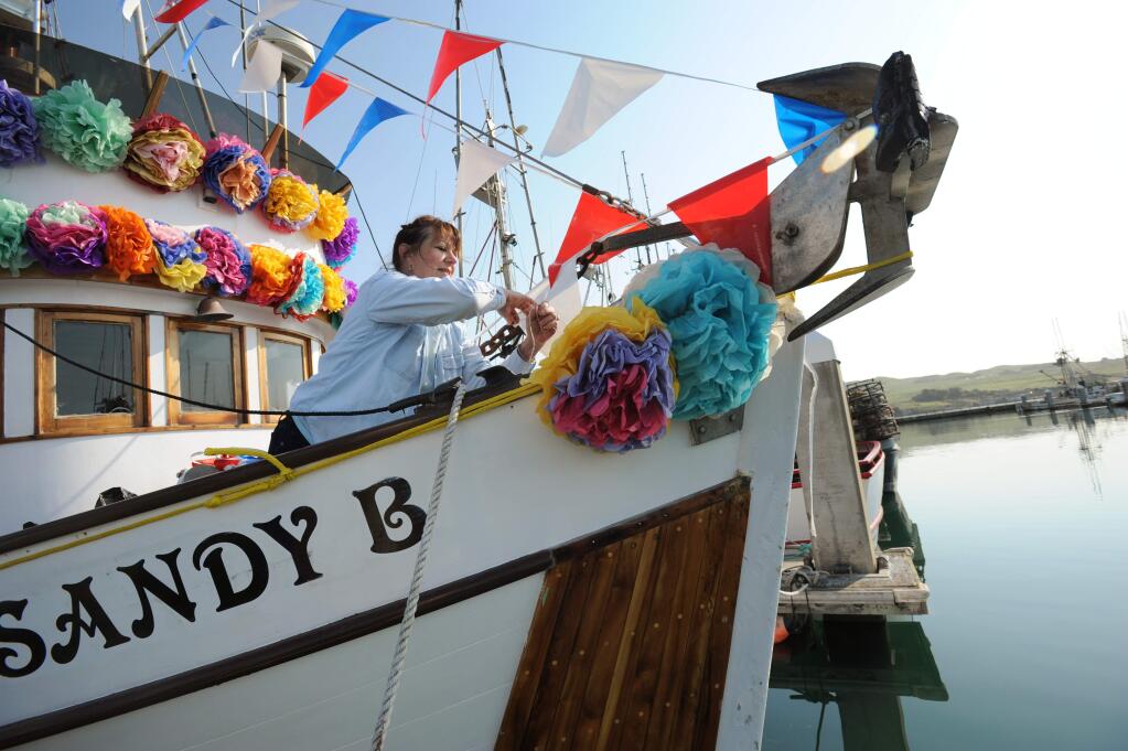 Leslie Maggio decorating the Sandy B with tissue paper flowers during preparations for the Blessing of the Fishing Fleet as part of the 44th Annual Bodega Bay Fisherman's Festival held Sunday in Bodega Bay. April 9, 2017.(Photo: Erik Castro/for The Press Democrat)