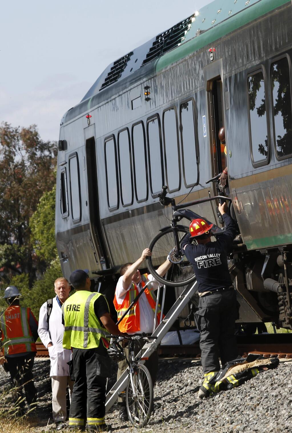 SMART officials and Rincon Valley firefighters unload passengers and bicycles from the damaged forward train car at the scene of a SMART train and truck collision at the Todd Road crossing near Santa Rosa on Thursday, May 31, 2018. (BETH SCHLANKER/ PD)