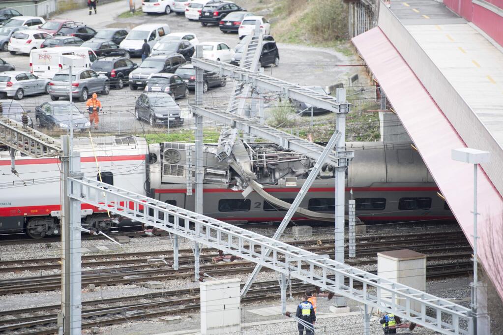 Rescuers stand next to a derailed train in the train station of Lucerne, Switzerland, Wednesday, March 22, 2017. Swiss police say they are trying to reach people trapped inside the train, with details of any injuries still unclear. Rail company SBB says the Milan to Basel train derailed Wednesday as it was pulling out of Lucerne's main train station. (Urs Flueeler/Keystone via AP)