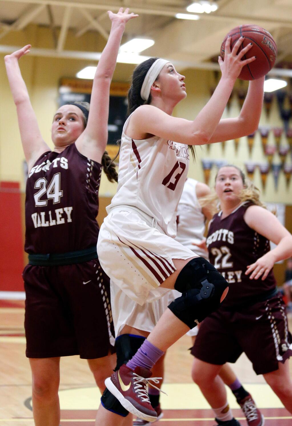 Cardinal Newman's Hailey Vice-Neat (13) gets around Scotts Valley's Sam Boyle (24) for a layup during the second half of the CIF NorCal girls basketball playoff game between Scotts Valley and Cardinal Newman high schools in Santa Rosa, California on Saturday, March 12, 2016. (Alvin Jornada / The Press Democrat)