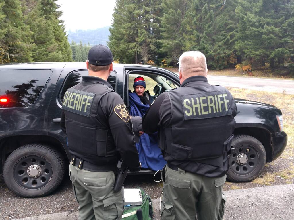 This photo provided by Marion County Sheriff's Office, hiker Robert Campbell sits in a police vehicle after being rescued by the Marion County Sheriff's Office Friday, Oct. 18, 2019, Campbell had been hiking the Pacific Crest Trail and got lost on Thursday in a snowstorm. (Marion County Sheriff's Office via AP)