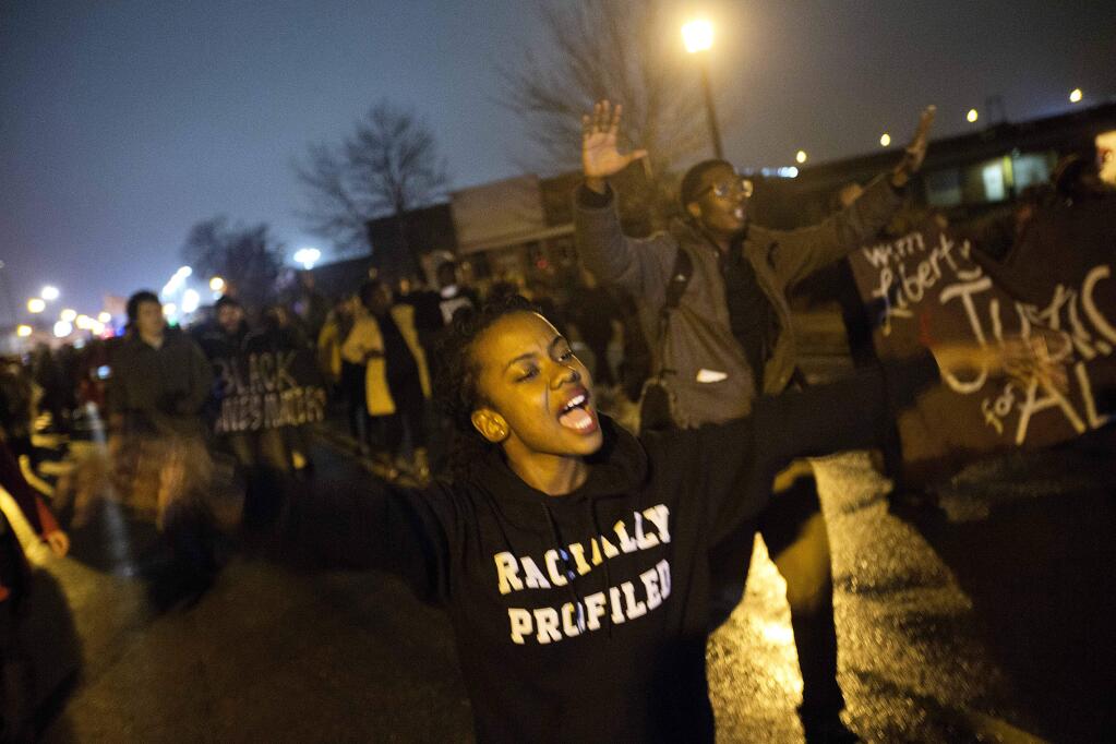 Brittany Ferrell, of St. Louis, chants 'hands up don't shoot' while marching through the streets protesting the August shooting of Michael Brown, Sunday, Nov. 23, 2014, in St. Louis. Ferguson and the St. Louis region are on edge in anticipation of the announcement by a grand jury whether to criminally charge officer Darren Wilson in the killing of 18-year-old Brown. (AP Photo/David Goldman)