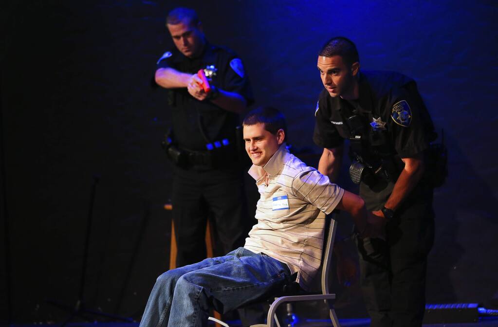 Andrew Kirk, who is autistic, volunteers to show how to comply with police officer commands, as Petaluma Police Officer Tyler Saldanha, right, and Cotati Police Officer Tyler Wardle pretend to arrest him during the Be Safe training program for law enforcement, and individuals with autism spectrum disorders, in Santa Rosa on Thursday, September 21, 2017. (Christopher Chung/ The Press Democrat)