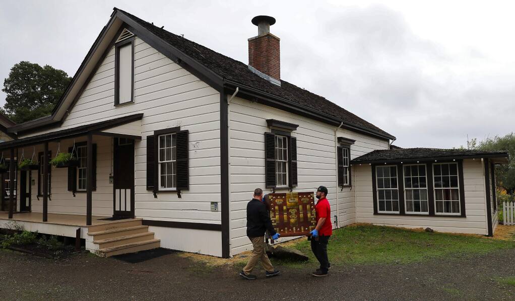 Sam Gomez, left, and Brad Pera, both of Wind Dancer Moving, return a Korean chest at the cottage in Jack London State Historic Park, in Glen Ellen on Thursday, November 16, 2017. Many artifacts were removed from the park when fires threatened the park last month.(Christopher Chung/ The Press Democrat)