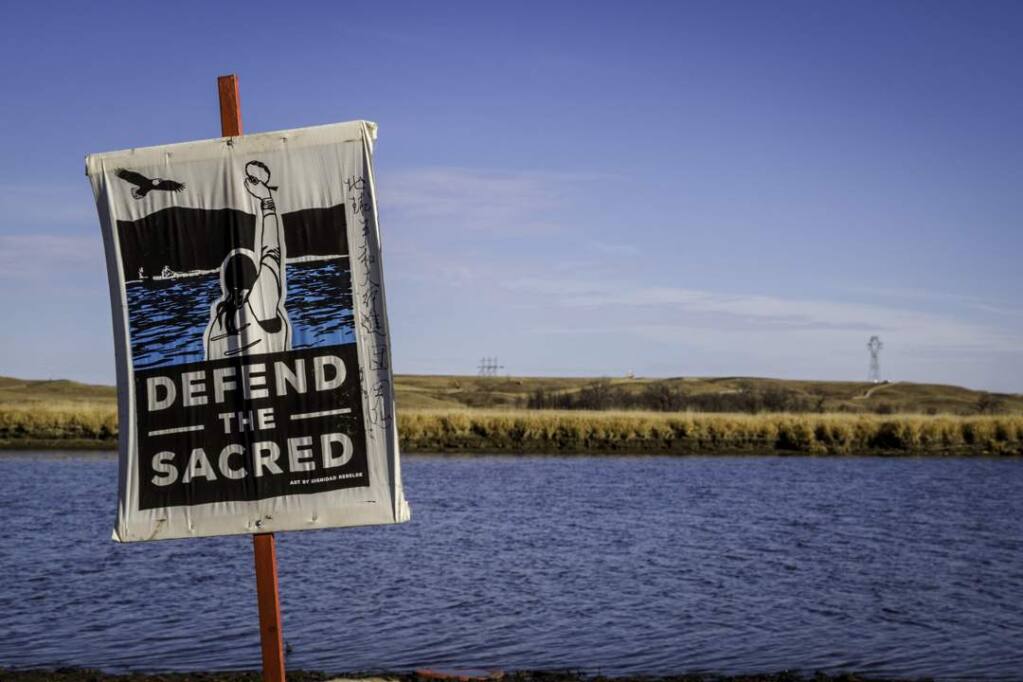 Banner on the banks of the Missouri River near the Standing Rock Sioux Reservation, where Native Americans and their supporters have been blocking a planned oil pipeline crossing since April, 2016. (Lisa Rani Photography/Used by permission)