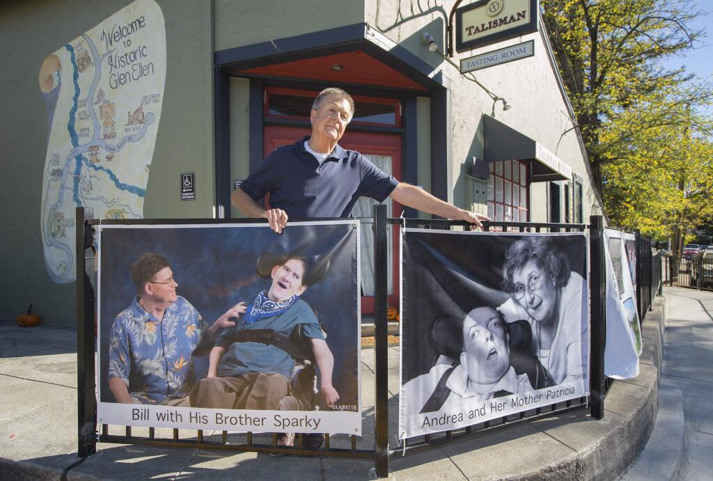 Photographer Christian Pease with a couple of the SDC photo banners that line the street from the Glen Ellen Star restaurant to the Glen Ellen Market. (Photo by Robbi Pengelly/Index-Tribune)