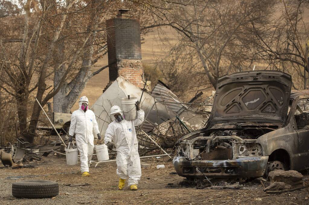 Workers in hazmat suits search for hazardous materials in the ash of the former LaFranchi family home on their Oak Ridge Angus farm on Hwy 128. The buildings on the ranch were consumed by the Kincade fire. (photo by John Burgess/The Press Democrat)