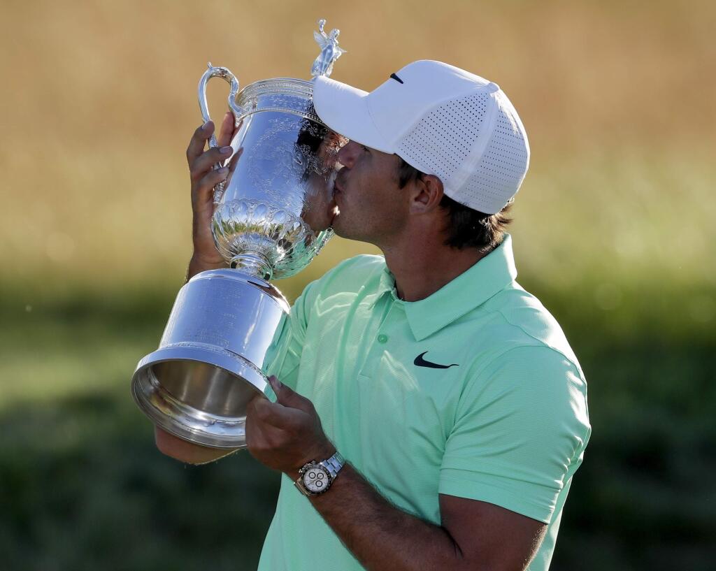 Brooks Koepka kisses the winning trophy after the U.S. Open golf tournament Sunday, June 18, 2017, at Erin Hills in Erin, Wis. (AP Photo/Chris Carlson)