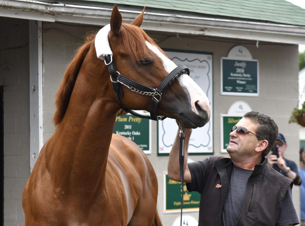 Triple Crown winner Justify, and assistant trainer Jimmy Barnes look at each other following his arrival at Churchill Downs, Monday, June 11, 2018, in Louisville, Ky. (AP Photo/Timothy D. Easley)