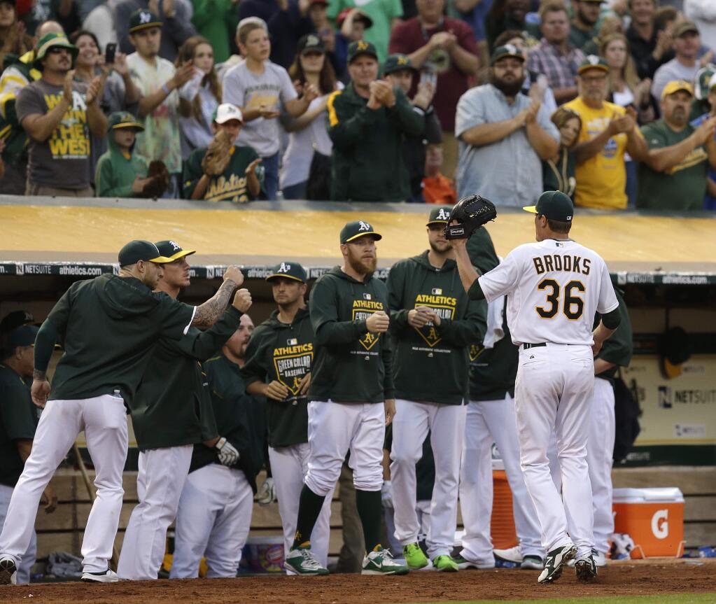 Oakland Athletics pitcher Aaron Brooks (36) is congratulated by teammates after being removed from the game against the Cleveland Indians in the eighth inning Saturday, Aug. 1, 2015, in Oakland. (AP Photo/Ben Margot)