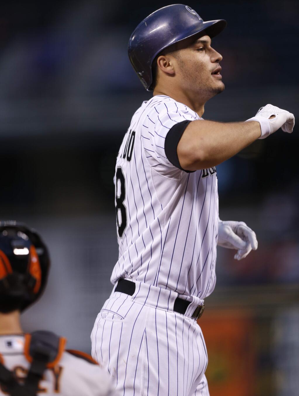 Colorado Rockies' Nolan Arenado celebrates as he crosses home plate after hitting a solo home run off San Francisco Giants starting pitcher Chris Heston in the first inning of a baseball game Friday, Sept.. 4, 2015, in Denver. (AP Photo/David Zalubowski)