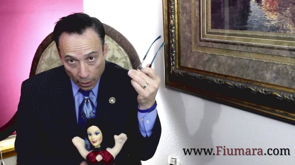 Defense lawyer Michael Fiumara pretends to question a doll seated on his lap in a video posted on YouTube.
