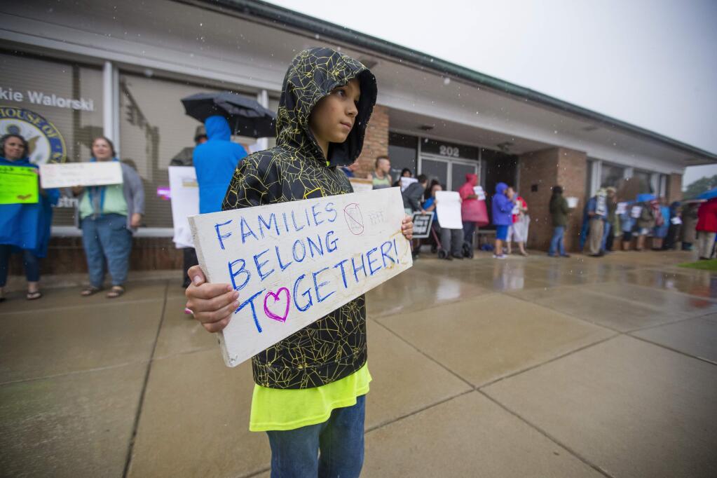 Sam Hernandez, 11, holds a sign during a protest hosted by the group¬†Indivisible Indiana District 2 at Representative Jackie Walorski's office Thursday, June 21, 2018, in Mishawaka, Ind. A crowd of people protested the separation of migrant children from their families at the border. (Michael Caterina/South Bend Tribune via AP)