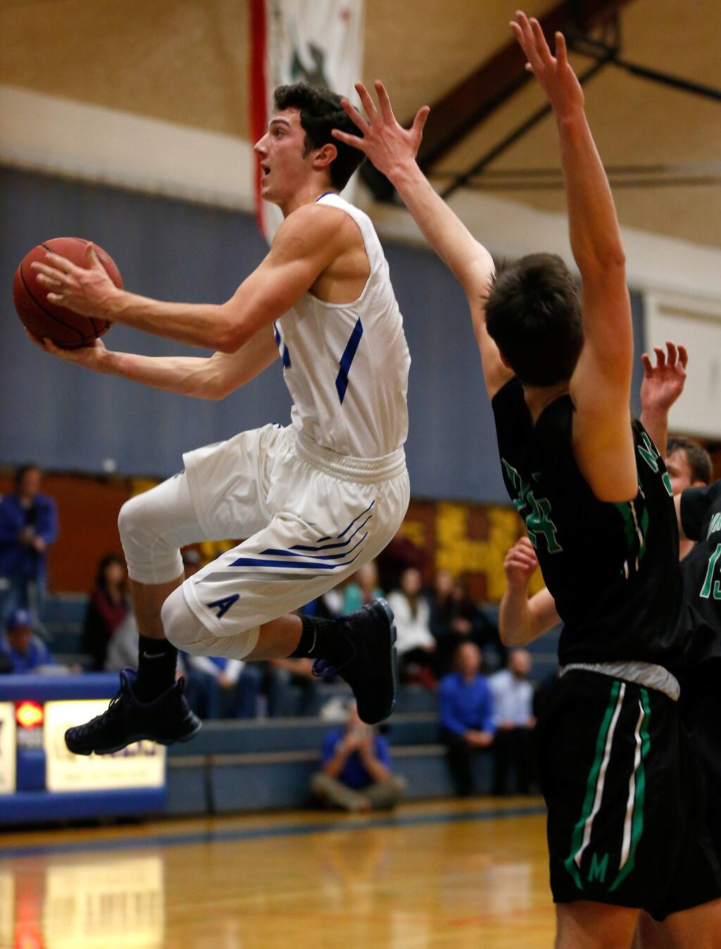 Analy's Dom Tripodi (11), left, leaps past Miramonte's Charlie Hocking (24) to score with a layup during the first half of the NCS Division 2 boys varsity basketball quarterfinal game between Miramonte and Analy high schools in Sebastopol, California on Friday, February 24, 2017. (Alvin Jornada / The Press Democrat)