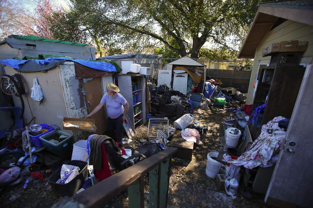 Homeowner John Vincent sifts through items in the backyard of his condemned Richmond Drive home in Santa Rosa on Monday, March 13, 2017. (Christopher Chung/ The Press Democrat)
