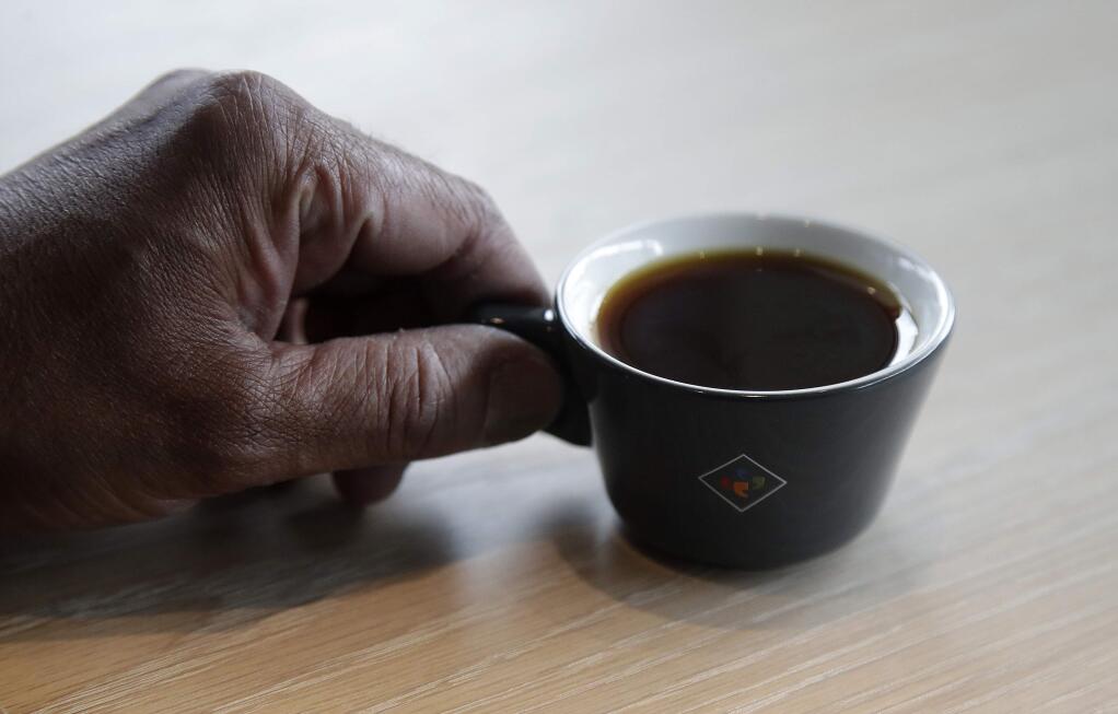 Klatch Coffee owner Bo Thiara holds a cup of Elida Natural Geisha coffee at his shop in San Francisco, Wednesday, May 15, 2019. The California cafe is brewing up what it calls the world's most expensive coffee - at $75 a cup. Klatch Coffee Roasters is serving the exclusive brew, the Elida Natural Geisha 803, at its branches in Southern California and San Francisco. (AP Photo/Jeff Chiu)