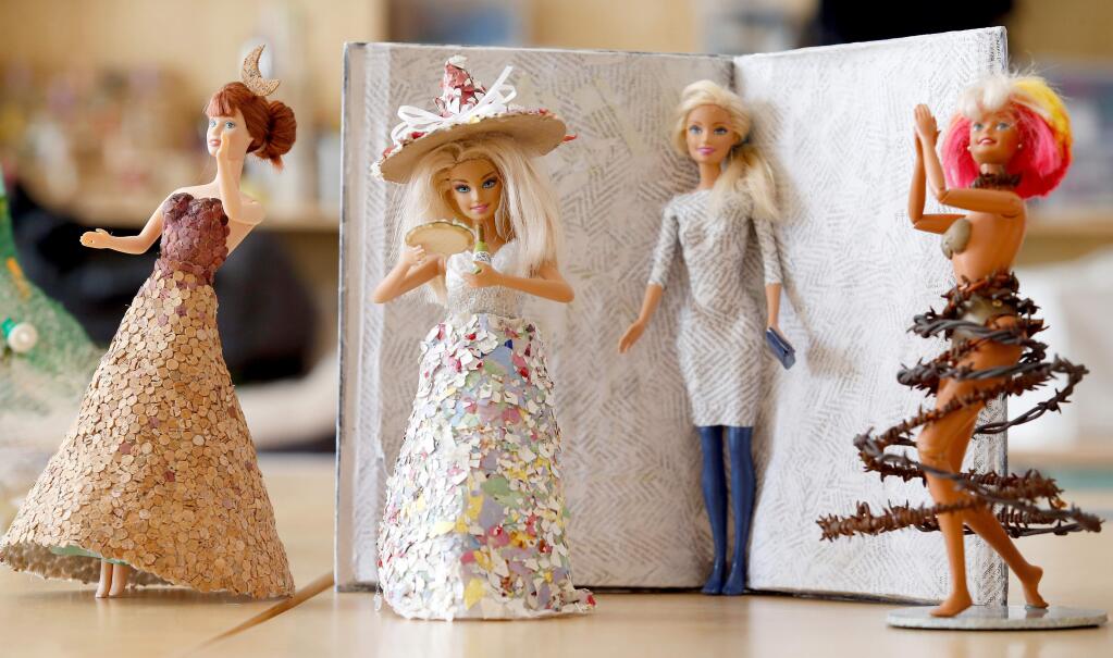 Various artists created Barbie doll couture with used and repurposed materials for the Trashion Fashion Show at the Sonoma Community Center in Sonoma, California, on Saturday, March 11, 2017. From left: a ball gown made from cork dots, by Kaala Stewart; a dress with matching hat covered in egg shells, by Susan Drake; a literary Barbie with a dress made from page clippings affixed in a paper mache book, by Wendy Stewart; and a dancing Barbie wearing barbed wire, by Jim Callahan. (Alvin Jornada / The Press Democrat)