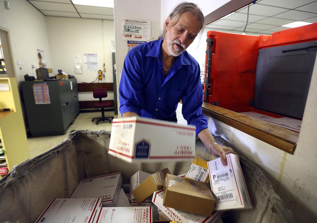 Photos by JOHN BURGESS / The Press DemocratForestville postmaster Kerry Adams sorts packages.