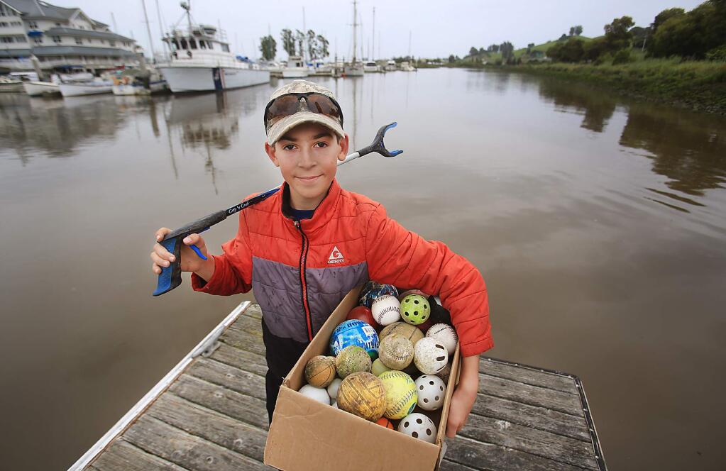DJ Woodbury displays just some of the items in the more than 2,200 pounds of garbage he fished from the Petaluma River as part of his Petaluma Live Oak Charter School service project on Monday, April 17, 2017. (KENT PORTER/ PD)