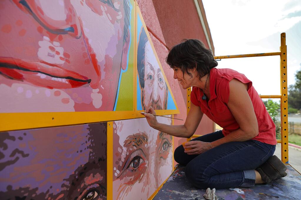 Artist Jennifer Tatum touches up the Palms Inn Project in Santa Rosa on Tuesday, September 12, 2017. (Christopher Chung/ The Press Democrat)