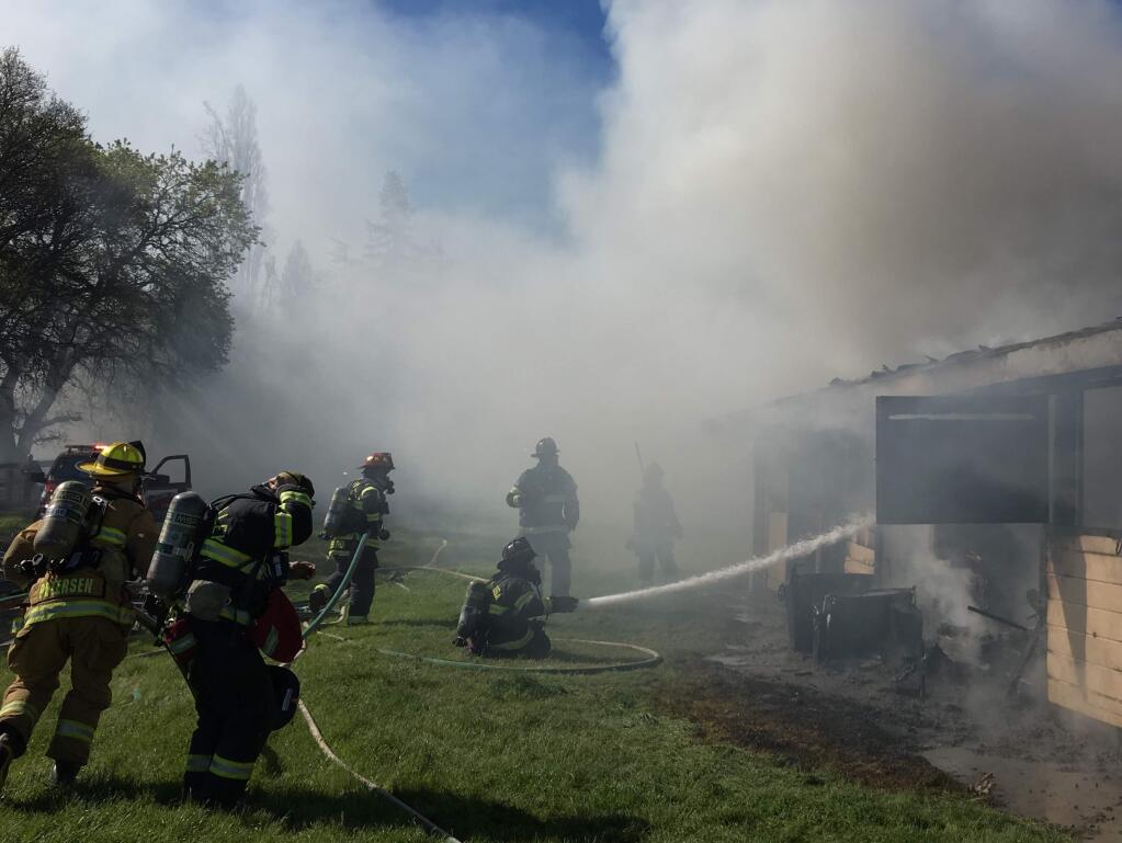 Firefighters battle a barn blaze on Occidental Road in west Santa Rosa on Friday, March 31, 2017. (KENT PORTER/ PD)
