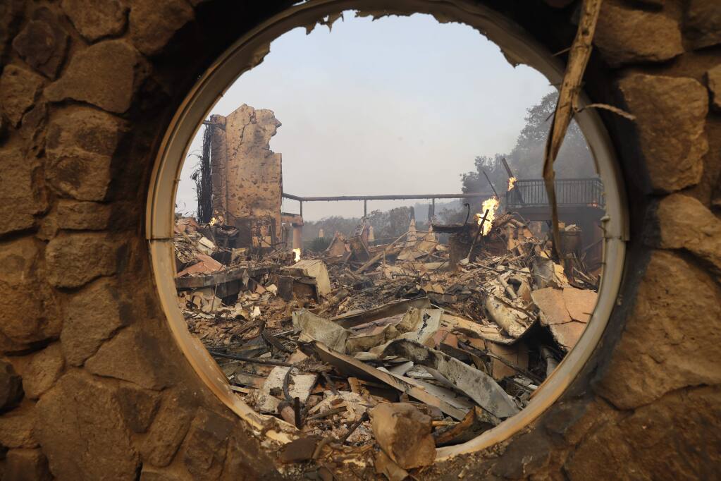 The fire-ravaged Signorello Estate winery is seen through a window Monday, Oct. 9, 2017, in Napa, Calif. Wildfires whipped by powerful winds swept through Northern California sending residents on a headlong flight to safety through smoke and flames as homes burned. (AP Photo/Marcio Jose Sanchez)