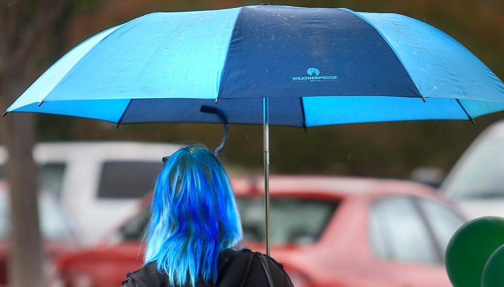 A woman walks through the rain in Santa Rosa in this file photo (Kent Porter / Press Democrat)