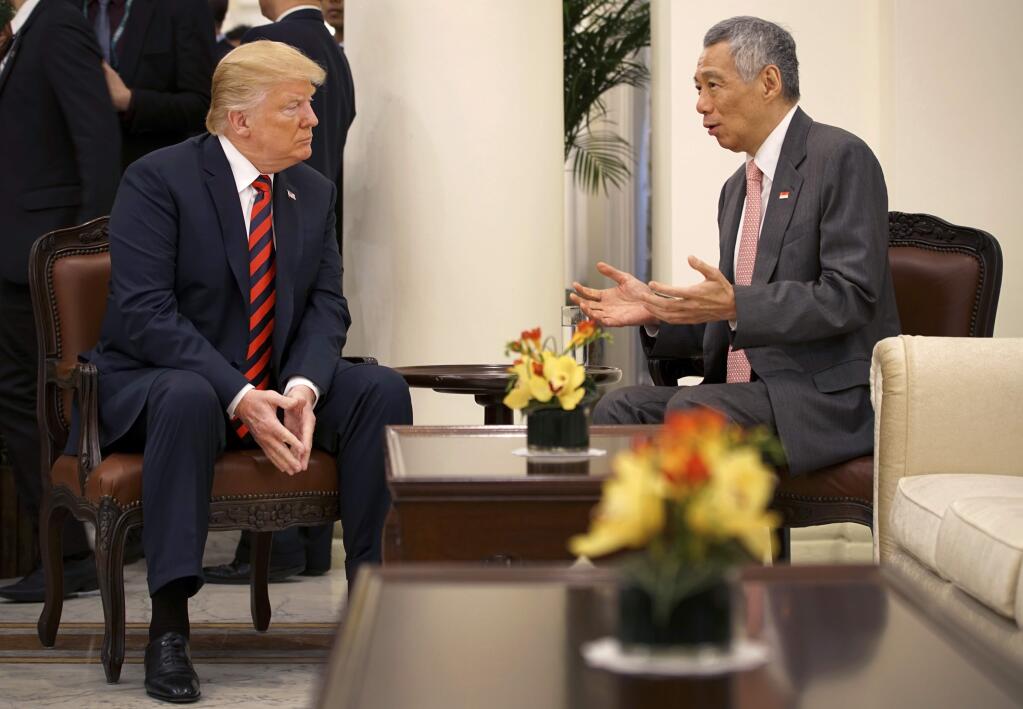 In this photo released by the Ministry of Communications and Information of Singapore, U.S. President Donald Trump, left, talks with Singapore Prime Minister Lee Hsien Loong ahead of a summit with North Korean leader Kim Jong Un, Monday, June 11, 2018. (Ministry of Communications and Information Singapore via AP)