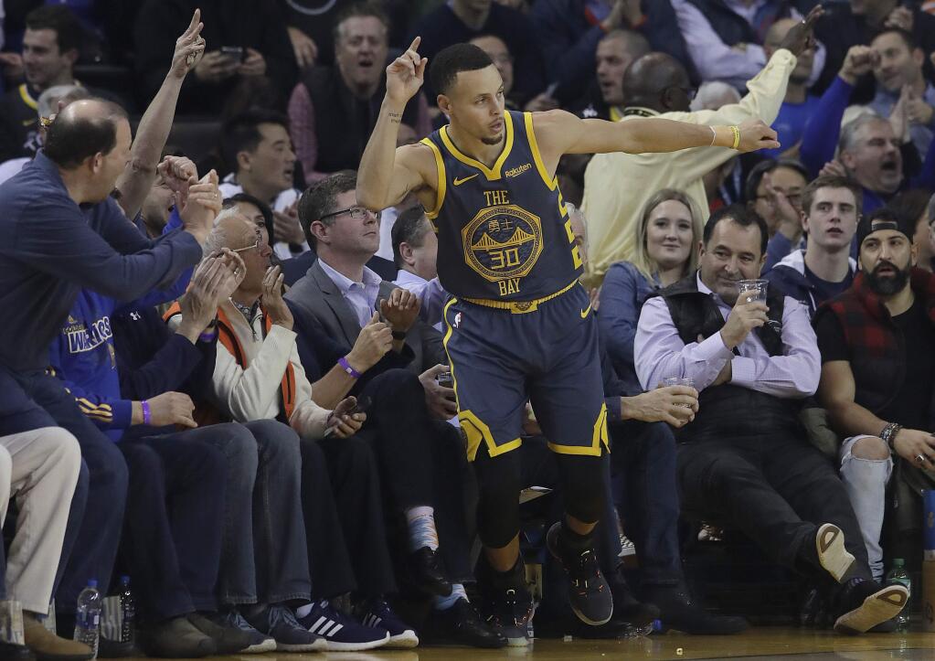 Golden State Warriors guard Stephen Curry reacts after scoring against the Toronto Raptors during the first half in Oakland, Wednesday, Dec. 12, 2018. (AP Photo/Jeff Chiu)