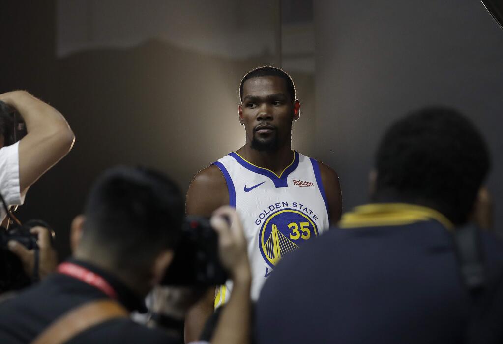 Golden State Warriors' Kevin Durant poses for photos for a news photographer during media day at the NBA basketball team's practice facility in Oakland, Calif., Monday, Sept. 24, 2018. (AP Photo/Jeff Chiu)