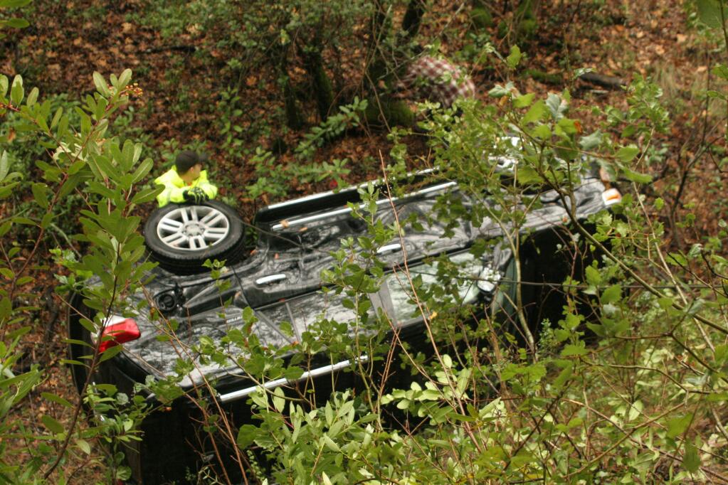 An SUV came to rest in a ravine off Lovall Valley Rd. in eastern Sonoma County on Tuesday, Oct. 25. Fire and rescue personnel prepare to recover the vehicle. (Christian Kallen/Index-Tribune)