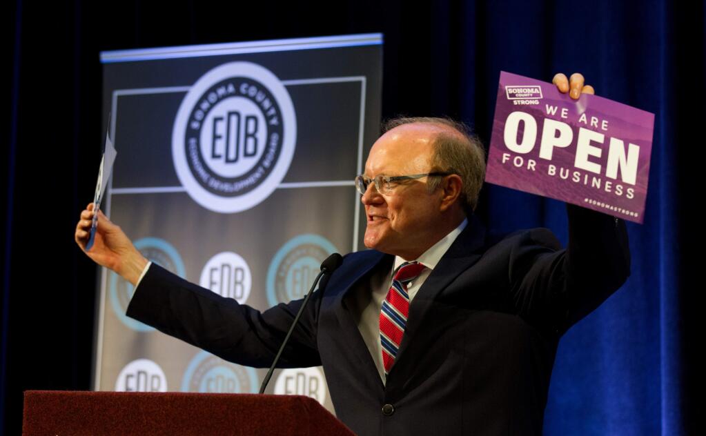Ben Stone, Executive Director of Sonoma County Economic Development Board, holds up a sign that says 'We Are Open For Business' at the Fall Economic Forecast meeting for Sonoma County Economic Development Board, at the Hyatt Regency in Santa Rosa, on Friday, November 17, 2017. (Photo by Darryl Bush / For The Press Democrat)